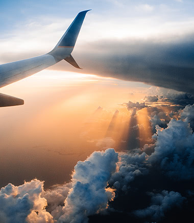 A view of the wing of an airplane flying through clouds.