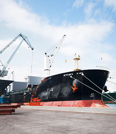 A large black ship docked at the dock.