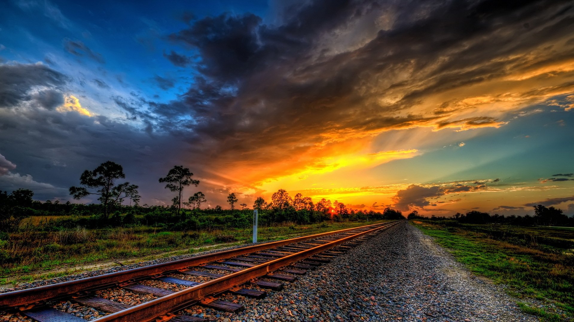 A train track with the sun setting in the background